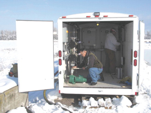 The interior of the mobile disinfection unit with two of the Tribe's engineering staff.