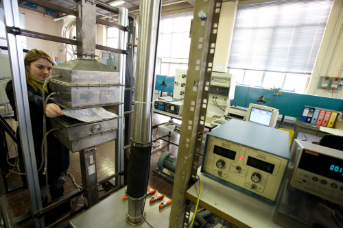 Flat-sheet filter media test system in the Politecnico laboratory. Left - 30 x 30 cm media holder; Centre - (in distance) laser particle counter/spectrometer; Right - controls for corona-discharge aerosol neutraliser, and electrometer for Faraday Cup aerosol charge detector.