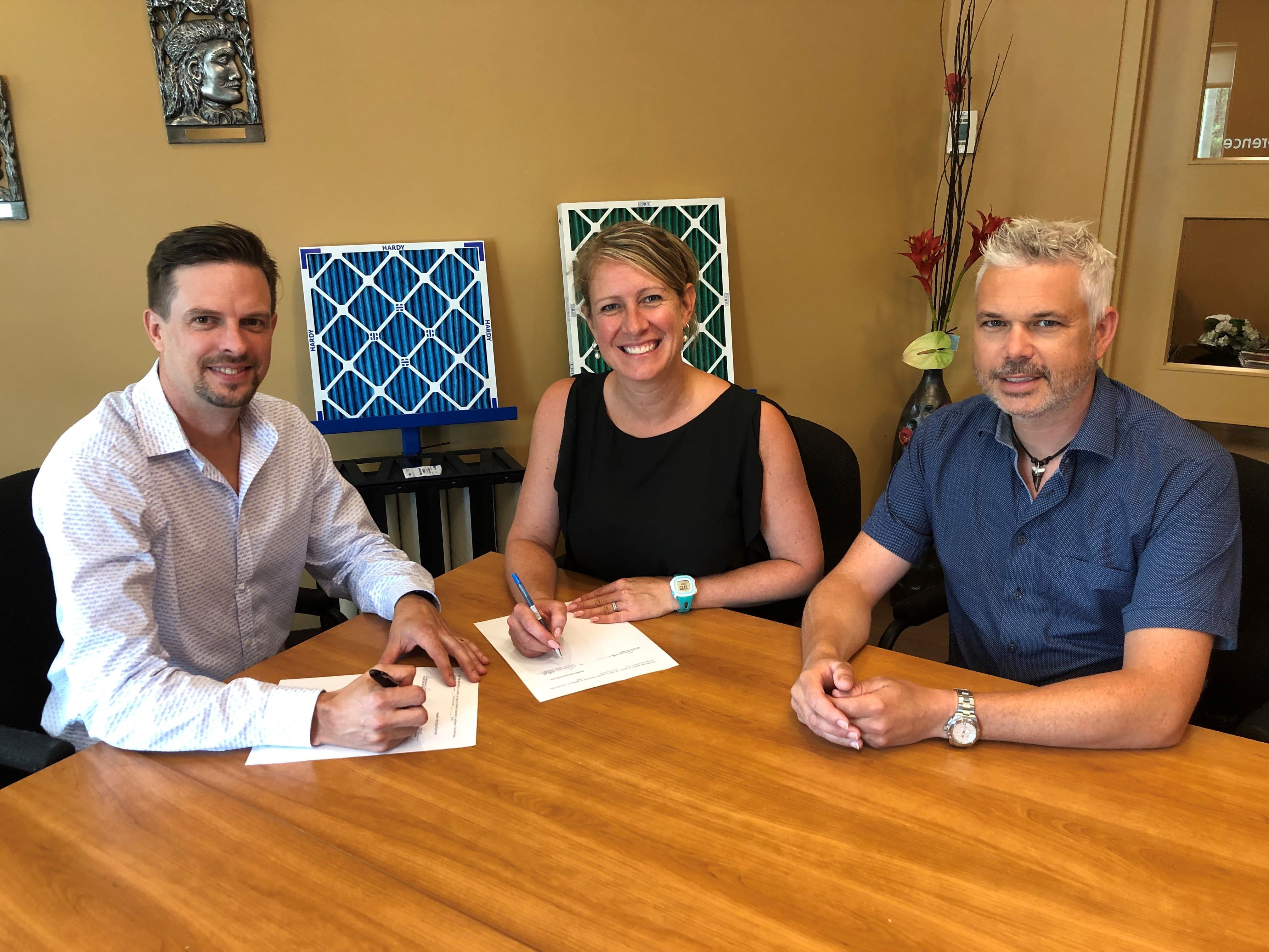 Signing the acquisition. Left to right: Graham MacDonald, Geneviève Hardy and Luc Girard.