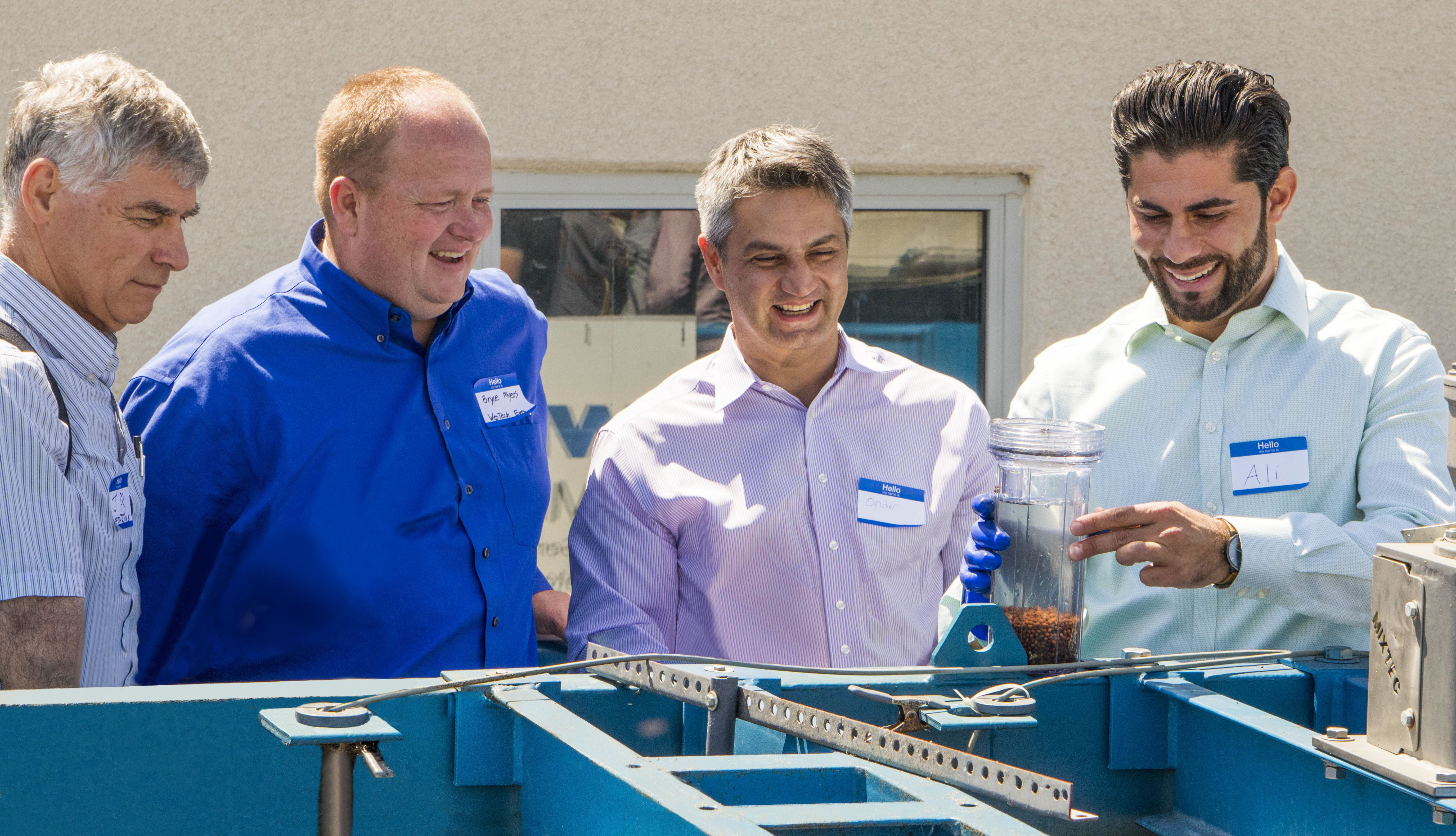 Visitors at the Oro Loma Sanitary District headquarters, look at a container of biocatalysts that have been pulled out of the bioreactor tank.