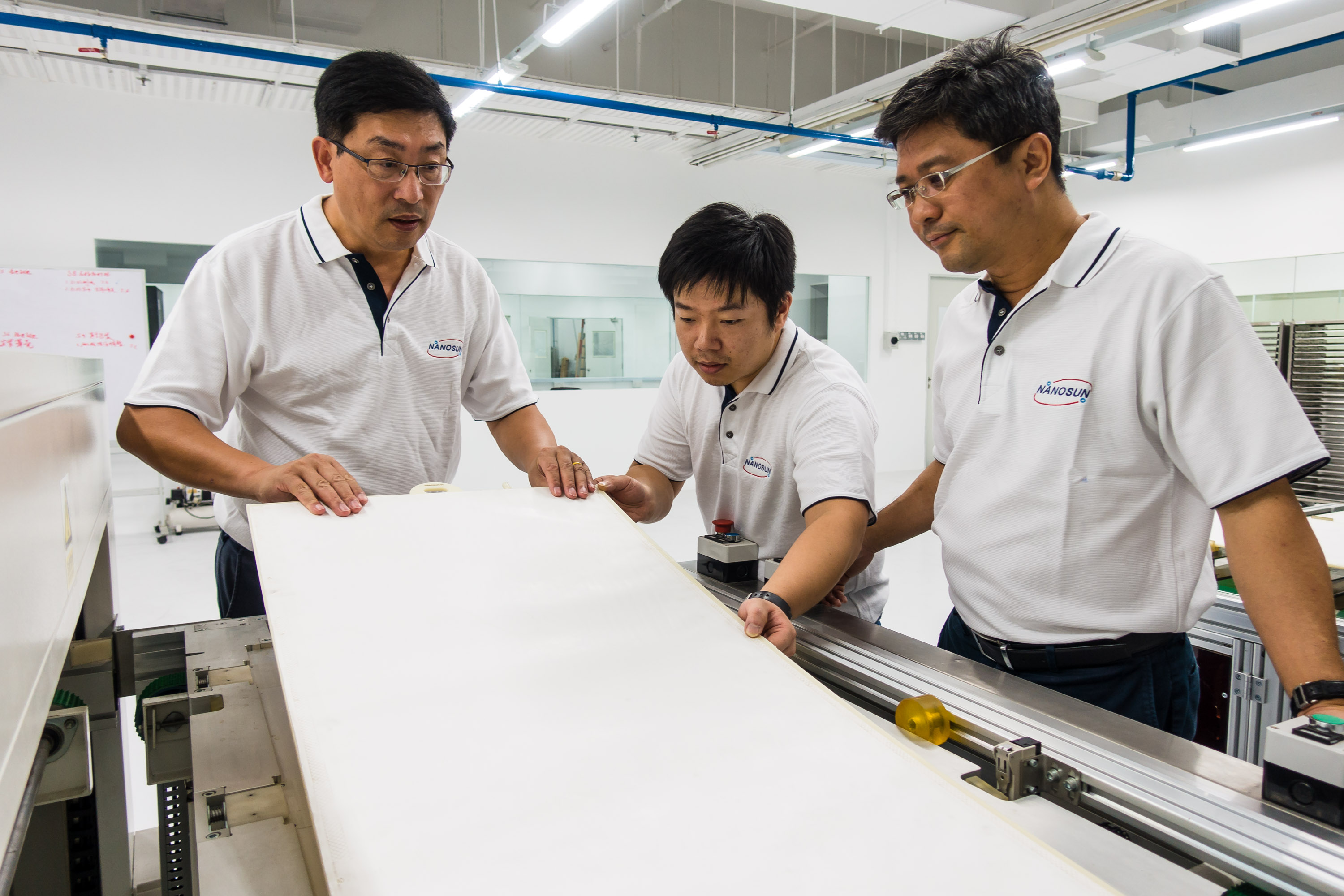 (L-R) Nano Sun founder and NTU Assoc Prof Darren Sun, engineer Zhang Lilin, and MD Wong Ann Chai doing visual inspection on a completed membrane module. Image courtesy of NTU Singapore.
