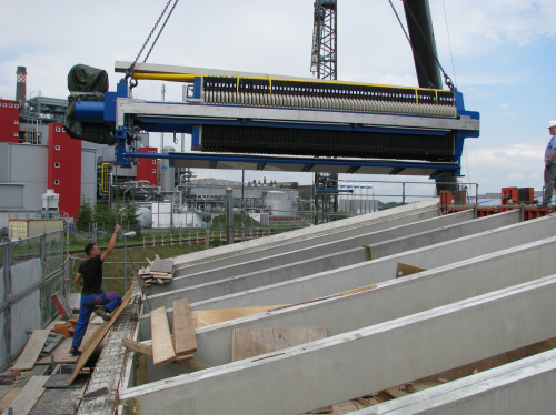 Figure 2: Filter press being lowered through the already installed top-floor rafters of the roof at SUC.