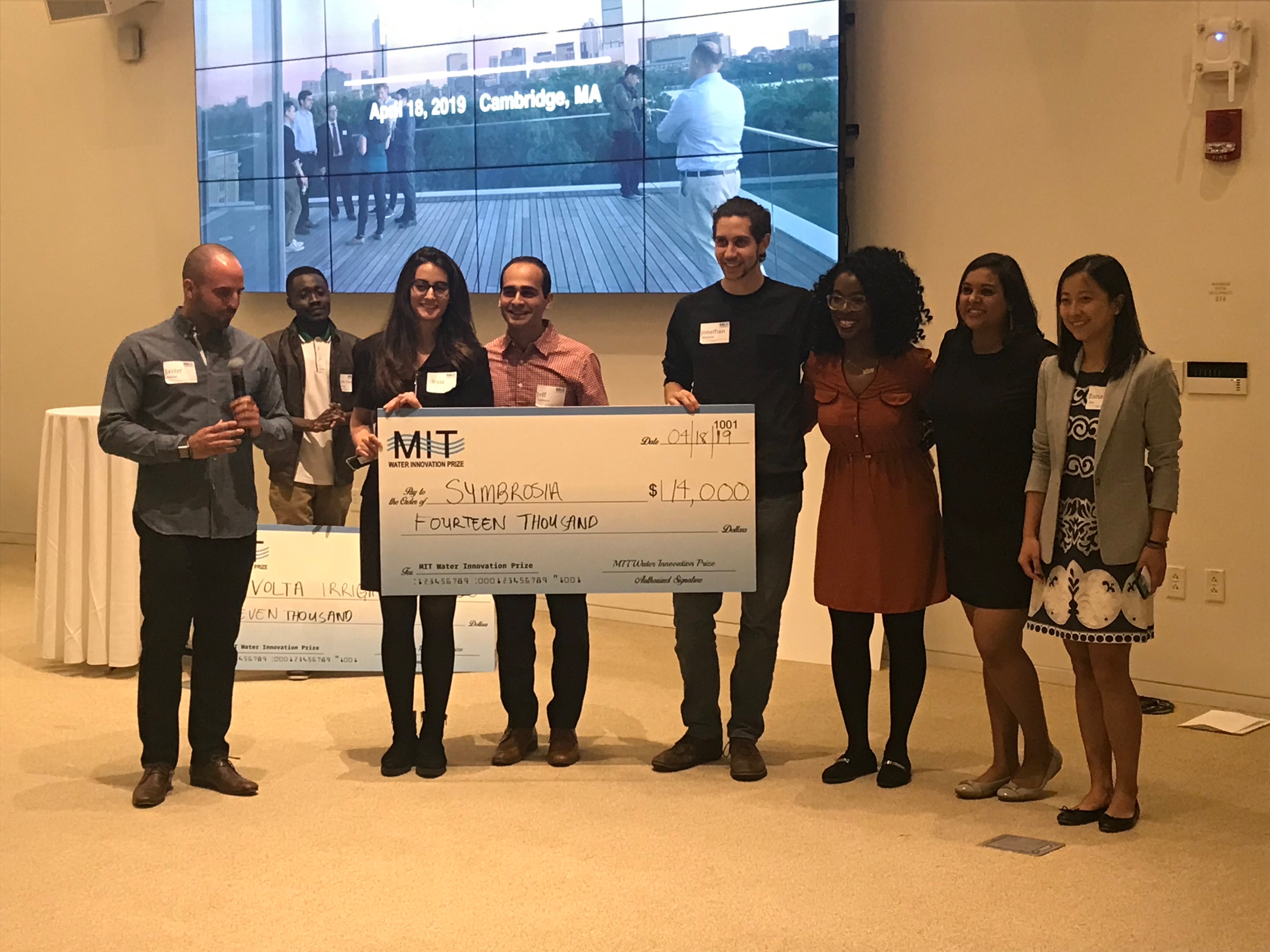 MIT MBA student Javier Renna (left) presents the MIT Water Prize winners with their award.